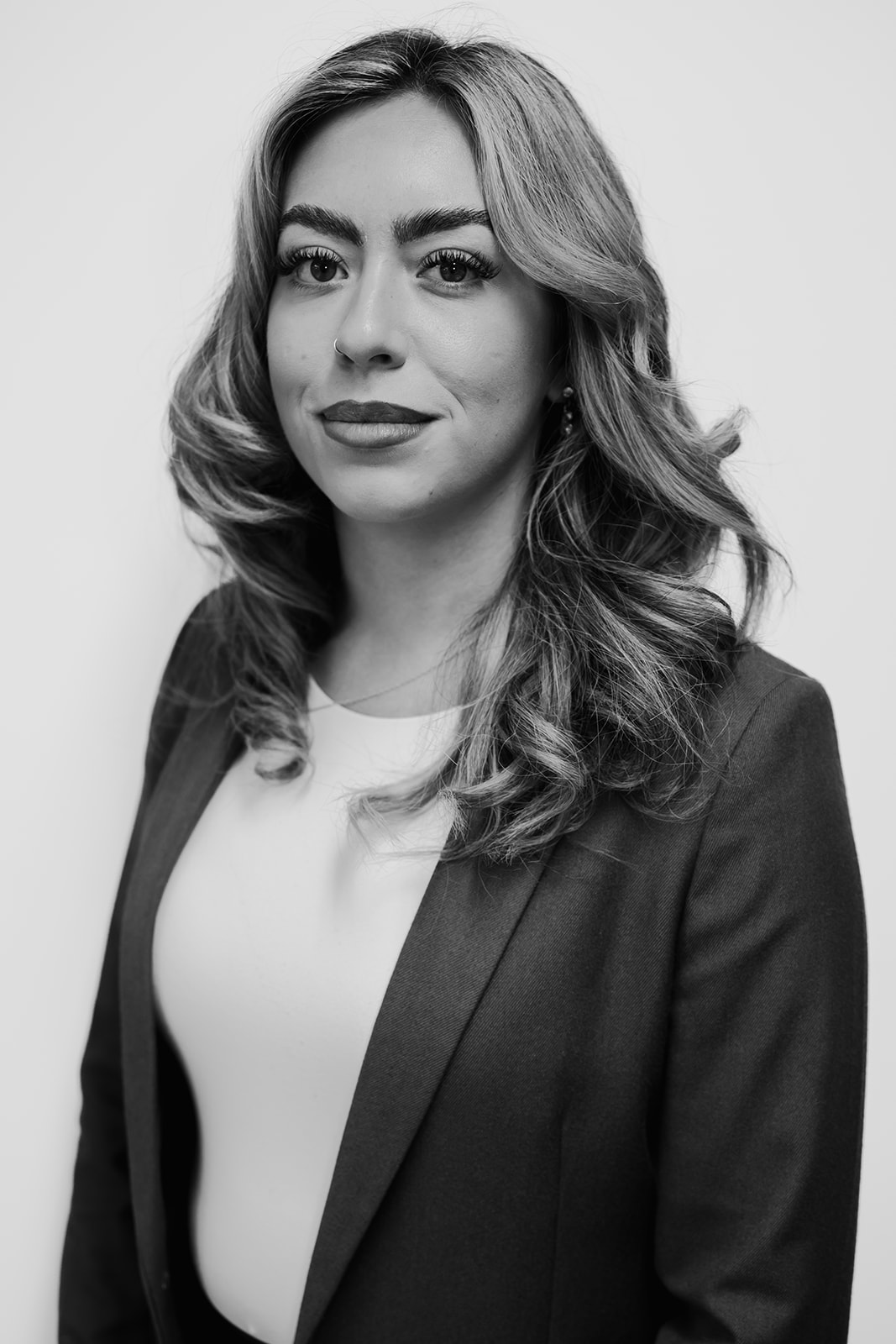 Professional woman in a suit, smiling confidently.