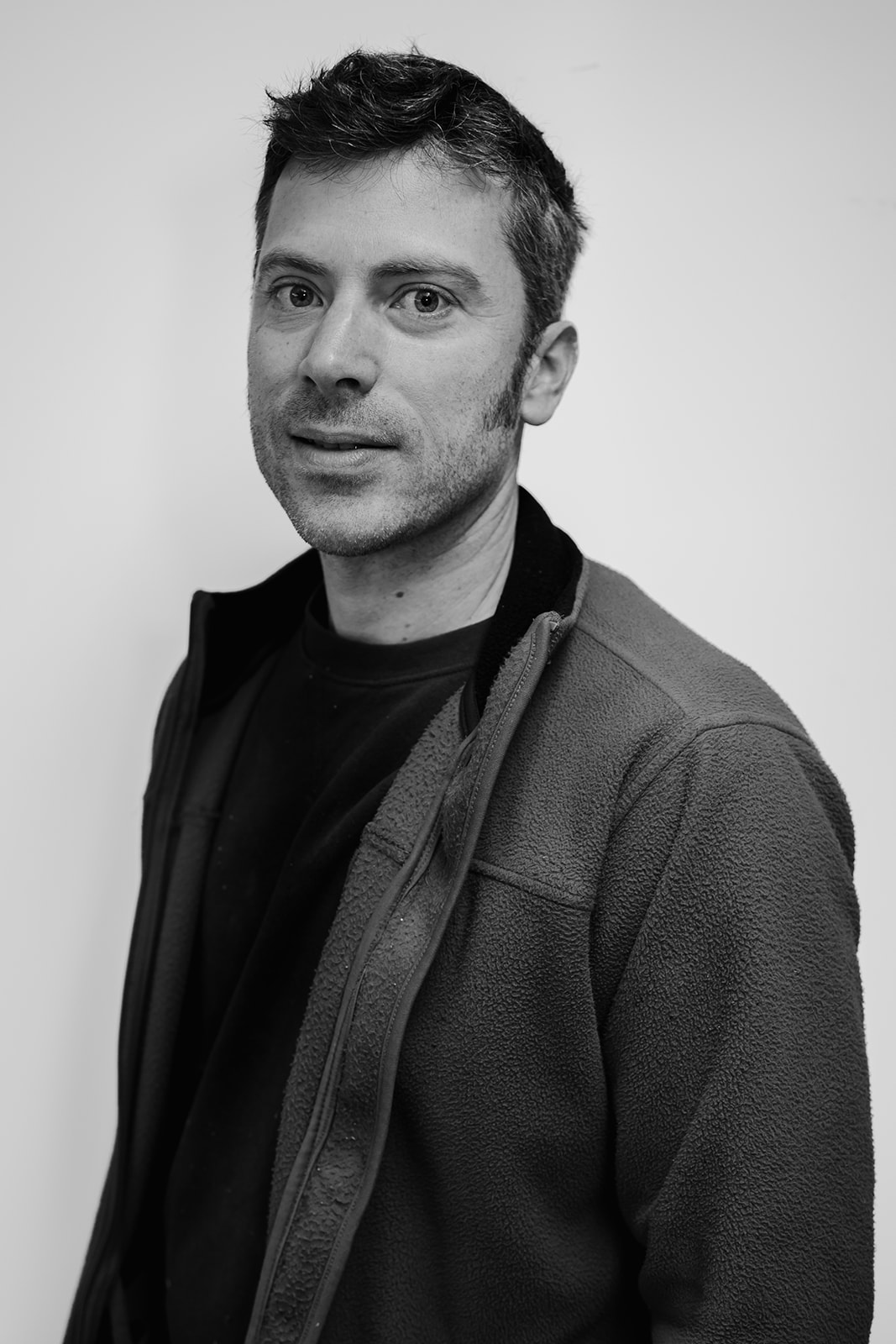 Man in fleece jacket, black and white portrait.