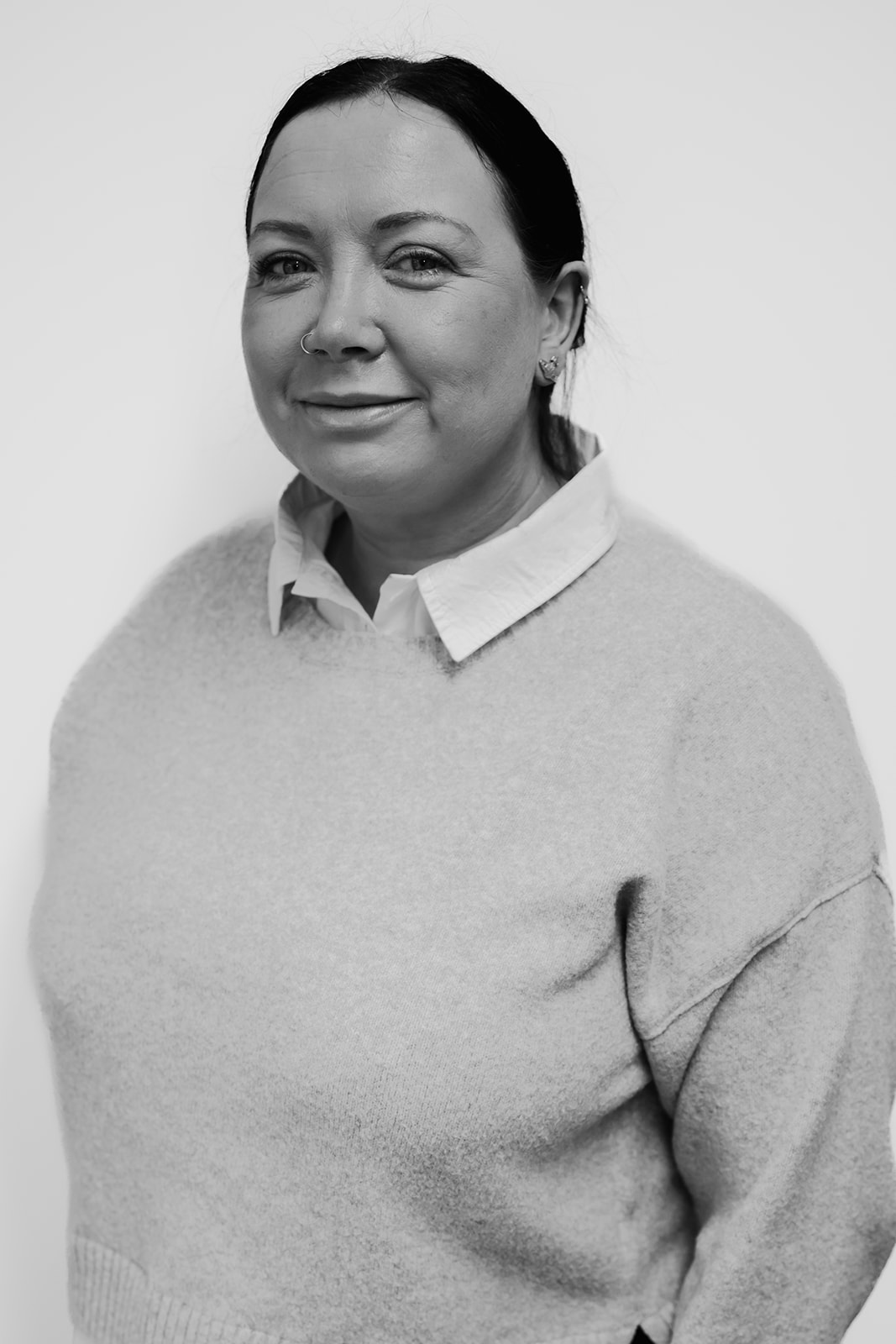 Person smiling in a black and white portrait