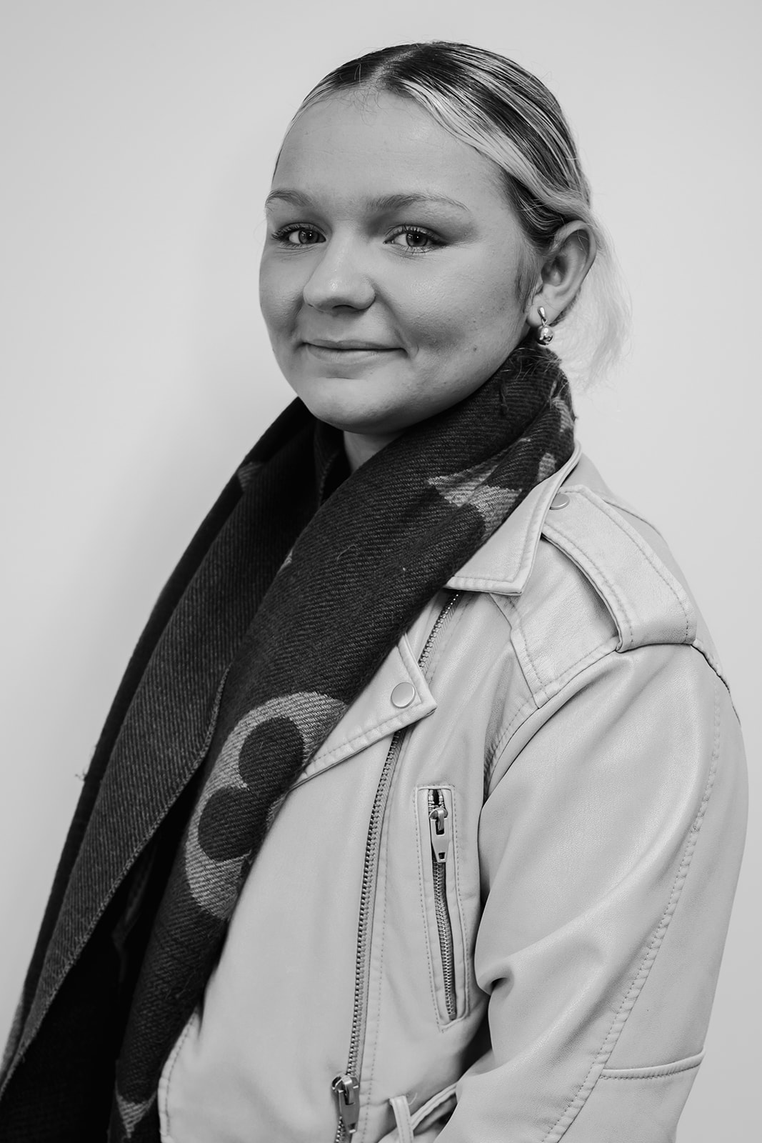 Smiling person wearing jacket and scarf in portrait