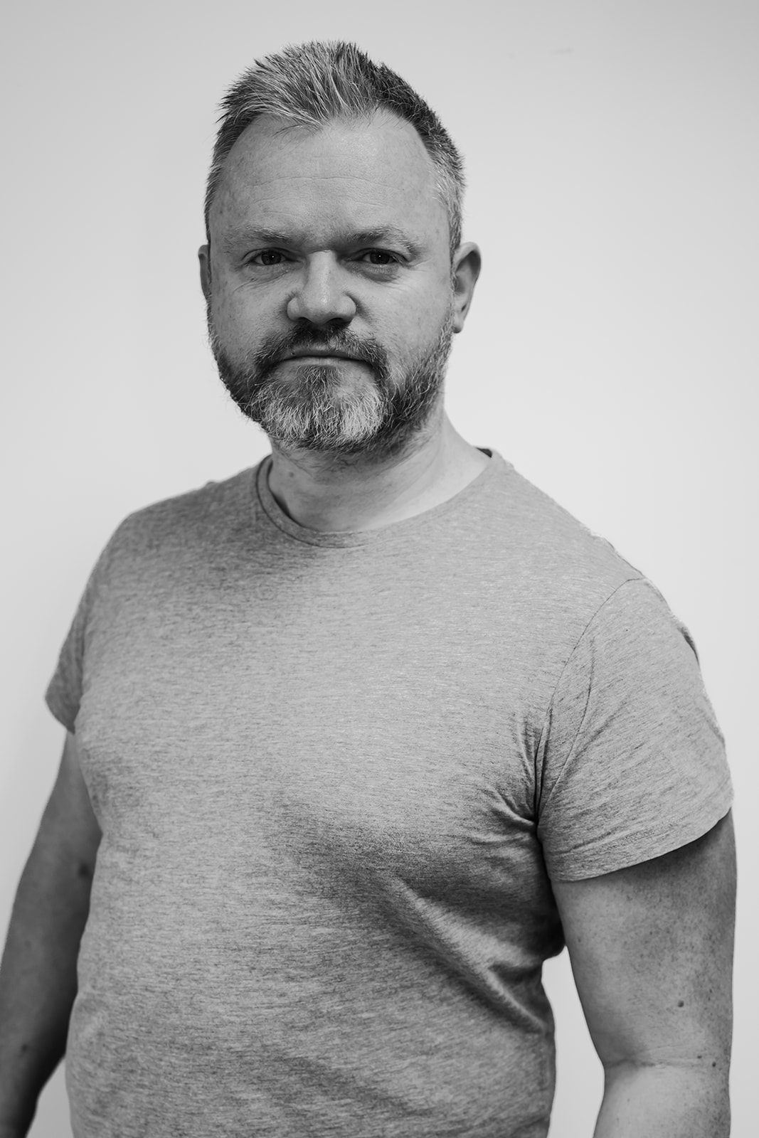 Bearded man in grey T-shirt, black and white photo.