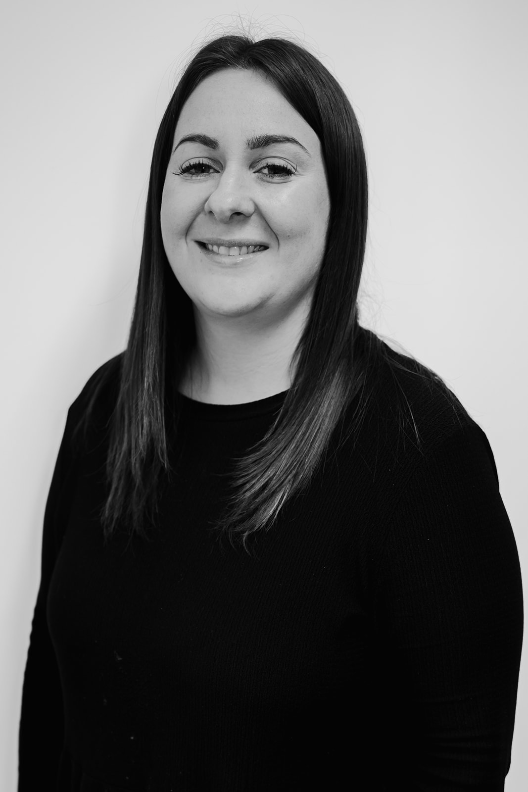 Smiling woman in black shirt, monochrome portrait.