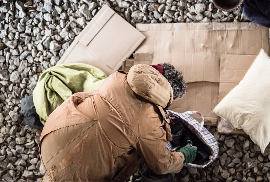 Person in coat arranging items on ground.